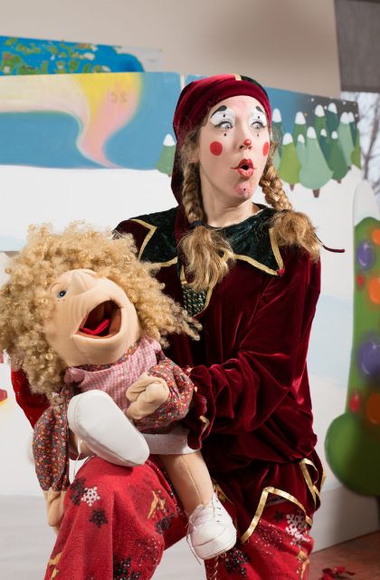 Actrice déguisée en lutin de Noël avec une marionnette